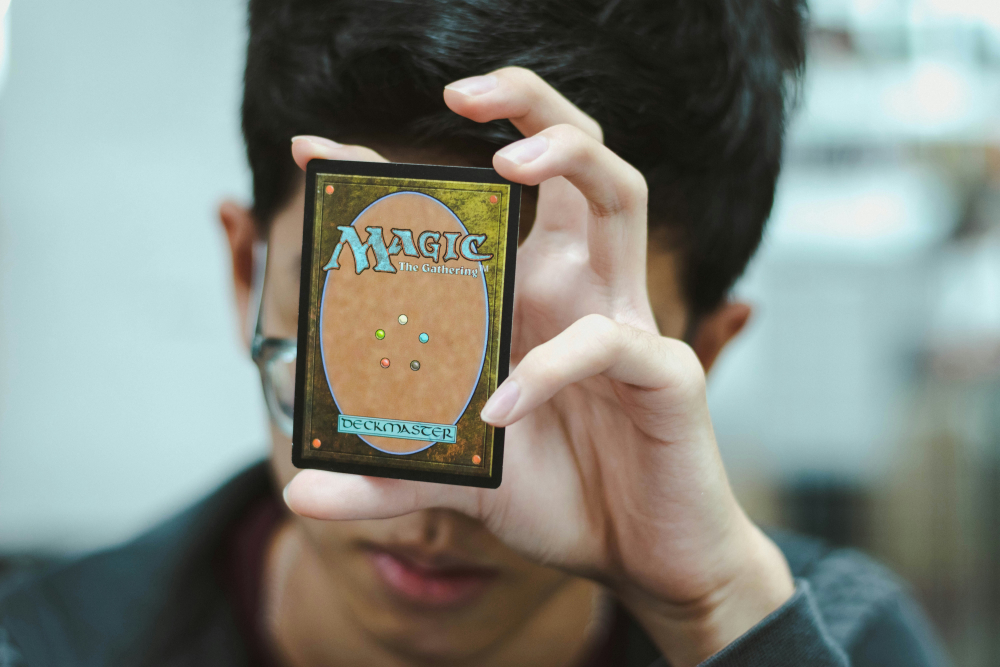 Decorative image of a person holding a MTG card in their hand.